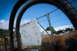 Blick auf die Baustelle im Schillerareal durch den Bauzaun mit Bauschild