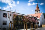 Gebäude des betreuten Wohnen mit blühenden Kirschbäumen im Vordergrund
