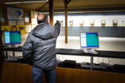 Schütze des Schützenvereins schießt am Schießstand auf eine entfernte Zielscheibe