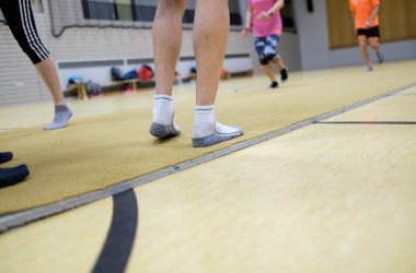 Sportler turnen auf einer gelben Gymnastikmatte